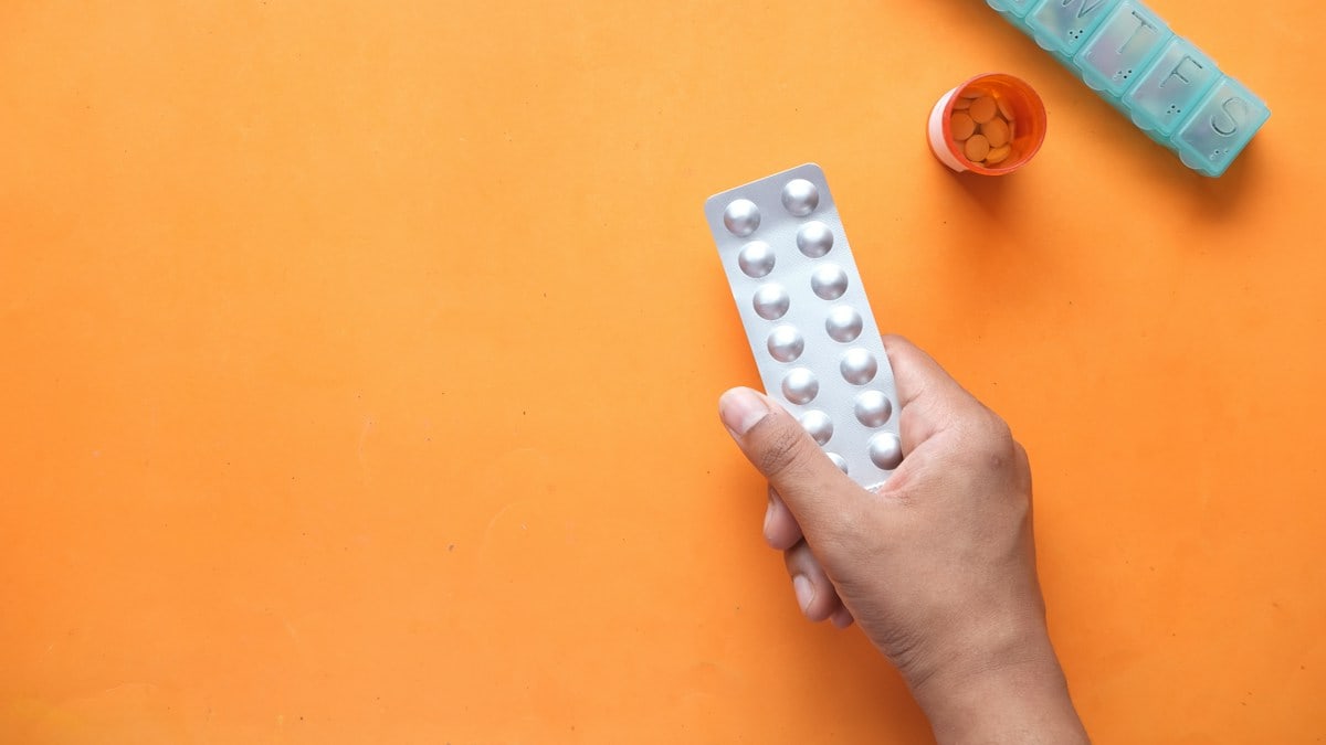 person holding white blister pack